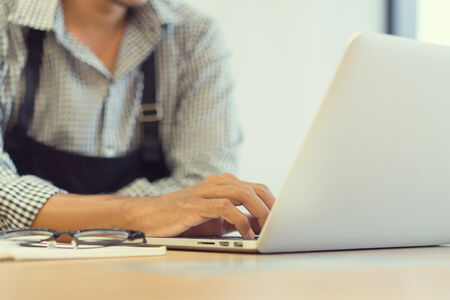 business owner working on laptop with glasses on the table