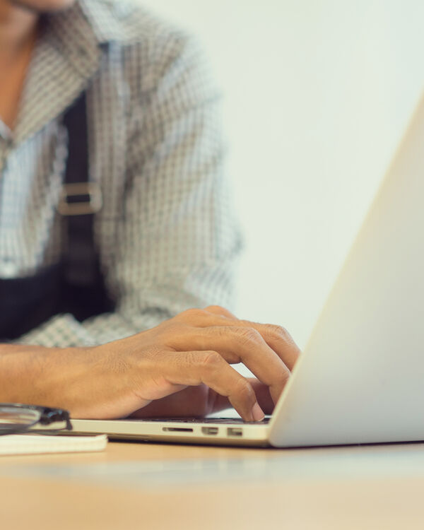 business owner working on laptop with glasses on the table