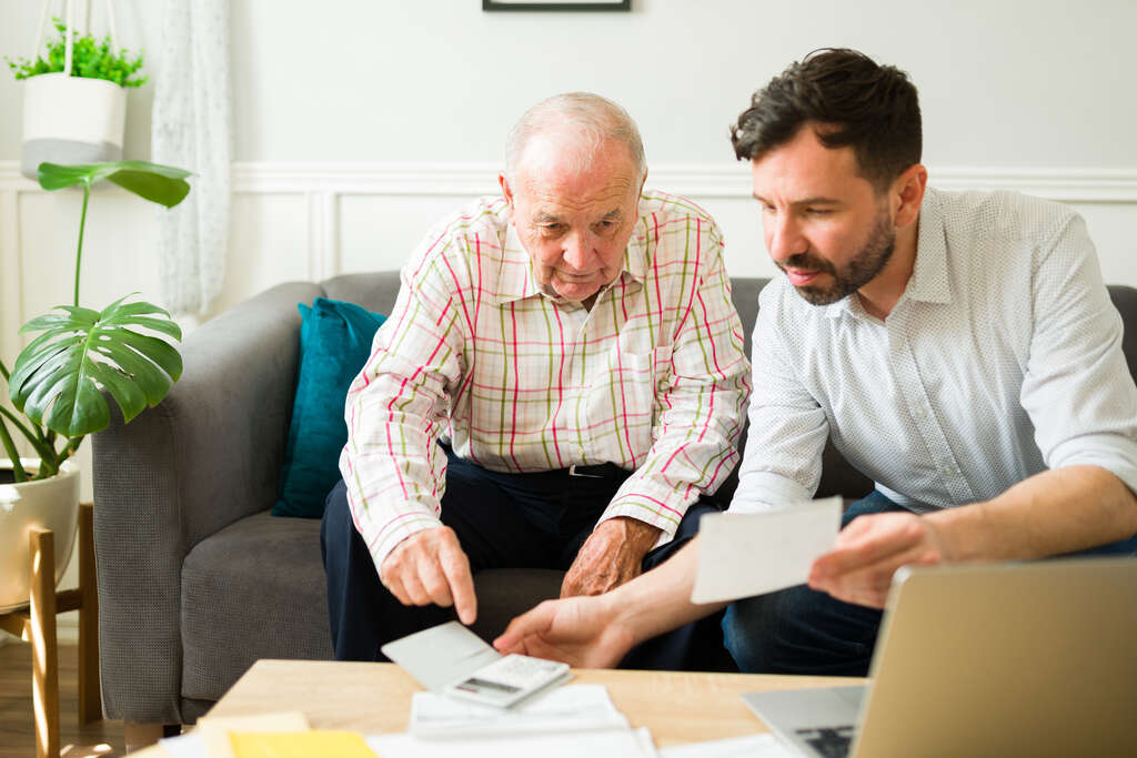 elderly man and younger man reviewing documents
